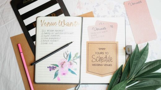 Open wedding planner notebook with a venue checklist, scheduling notes, and pens on a desk, helping couples organize their wedding venue tours.