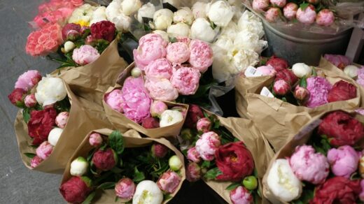 Beautiful bouquets of red, pink, and white peonies arranged for a wedding florist display.